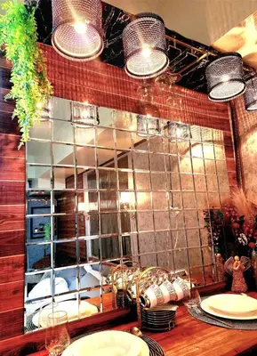 a mirror above a kitchen counter with plates and dishes at Avida Towers Sucat in Manila