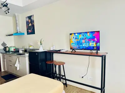 a room with a table with a television on top of it at SplashNStay 18sqm condi near AUP,PNPA CKS College Sta Rosa Tagaytay road Silang Cavite in Puting Kahoy
