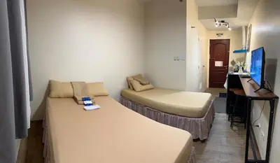 a small room with a bed and a desk with a computer at SplashNStay 18sqm condi near AUP,PNPA CKS College Sta Rosa Tagaytay road Silang Cavite in Puting Kahoy