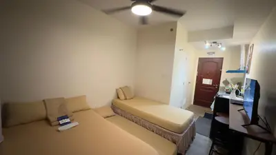 a small living room with a couch and a tv at SplashNStay 18sqm condi near AUP,PNPA CKS College Sta Rosa Tagaytay road Silang Cavite in Puting Kahoy
