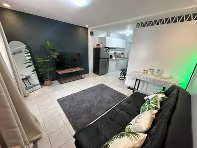 a living room with a couch and a kitchen at Cozy Hideout-Free Parking, Netflix & Arcade Games in Cainta
