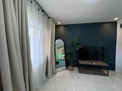 a living room with a tv and curtains at Cozy Hideout-Free Parking, Netflix & Arcade Games in Cainta
