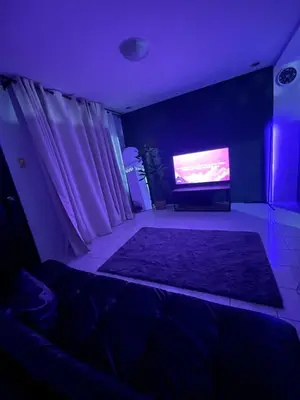a dark room with a tv and a couch and a rug at Cozy Hideout-Free Parking, Netflix & Arcade Games in Cainta