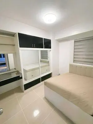 a bedroom with a bed and a large window at Family room Staycation Near MOA in Manila