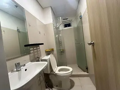 a bathroom with a shower and a toilet and a sink at Family room Staycation Near MOA in Manila