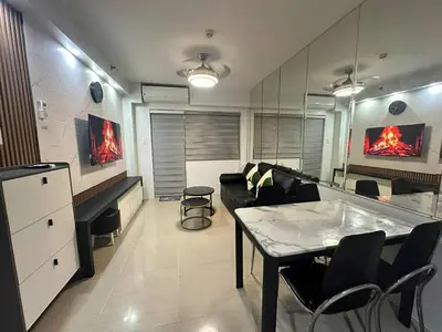 a living room with a couch and a table in it at Family room Staycation Near MOA in Manila