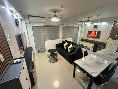a living room with a couch and a table at Family room Staycation Near MOA in Manila
