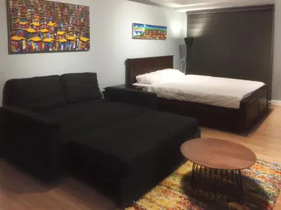 a bedroom with a bed and a couch and a table at Two Maridien 41stFlr Studio -Minimalist Functional in Manila