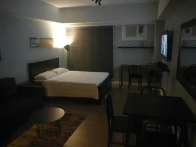 a hotel room with a bed and a table and chairs at Two Maridien 41stFlr Studio -Minimalist Functional in Manila