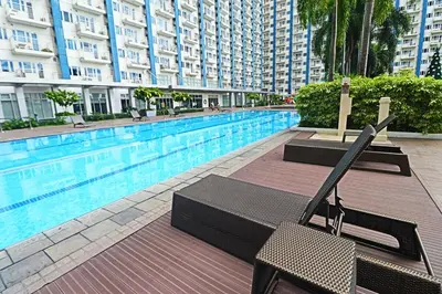 a swimming pool with a chair next to a building at A Comfy Self-Check-In and Check-out 1BR Light Residences in Manila