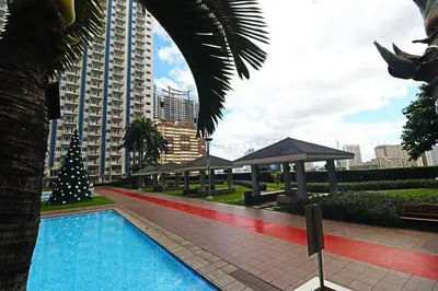 a swimming pool with a christmas tree next to a building at A Comfy Self-Check-In and Check-out 1BR Light Residences in Manila