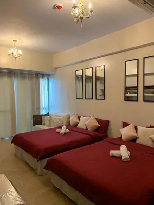 two beds in a room with red sheets at 81NB Cozy Studio -City View, 2 Queen Beds, NAIA T3 in Manila
