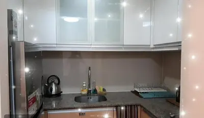 a kitchen with white cabinets and a sink at 81NB Cozy Studio -City View, 2 Queen Beds, NAIA T3 in Manila