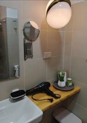 a bathroom with a sink and a mirror and a phone at RED LUXE HAVEN Comfy stay, Netflix and Fast WiFi Ready in Manila
