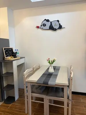 a dining room table and chairs with a clock on the wall at Sybay suites near okada MOA airport NAIA COD Manila MSV1806H in Manila