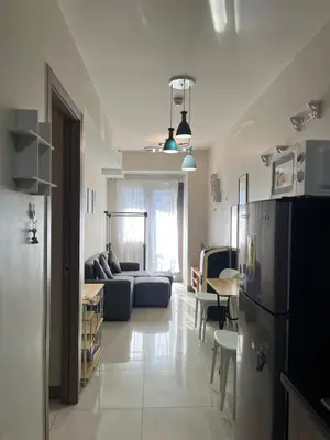 a living room with a couch and a refrigerator at 1 bedroom condo unit near MOA in Manila