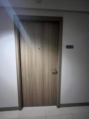 a wooden door in a room with a sign on it at 1 bedroom condo unit near MOA in Manila