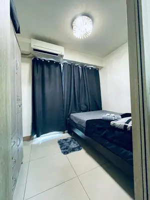 a small bedroom with a bed and a window at Minimalist Flat Retreat- Shore Residences in Manila