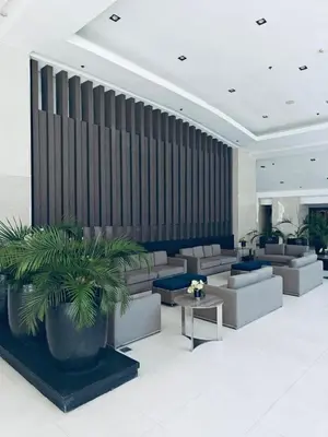 a lobby with couches and a plant in the middle at Minimalist Flat Retreat- Shore Residences in Manila