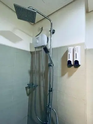 a shower with a shower head in a bathroom at Minimalist Flat Retreat- Shore Residences in Manila