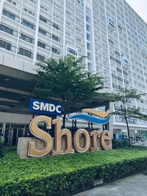 a sign in front of a large building at Minimalist Flat Retreat- Shore Residences in Manila
