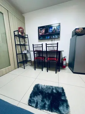 a dining room with a table and a refrigerator at Minimalist Flat Retreat- Shore Residences in Manila