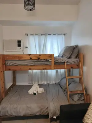 a bedroom with a bunk bed with a microwave at Green 2 Residences Tower1 unit 512 in Dasmariñas