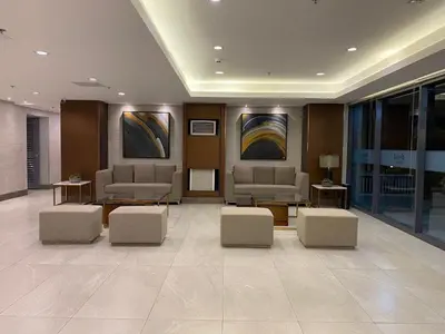 a waiting room with couches and tables and paintings at Green 2 Residences Tower1 unit 512 in Dasmariñas