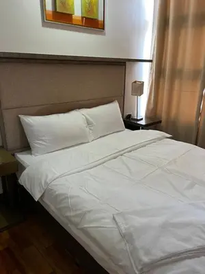 a bed with white sheets and pillows in a bedroom at Antel Spa Residences 9A in Manila