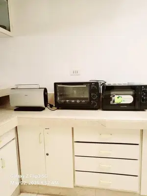 a kitchen counter with a microwave and a toaster oven at Majesty Suites in Manila