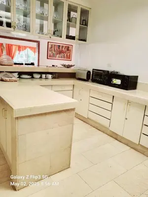 a kitchen with white cabinets and a black microwave at Majesty Suites in Manila