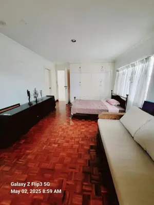a bedroom with two beds and a red brick floor at Majesty Suites in Manila