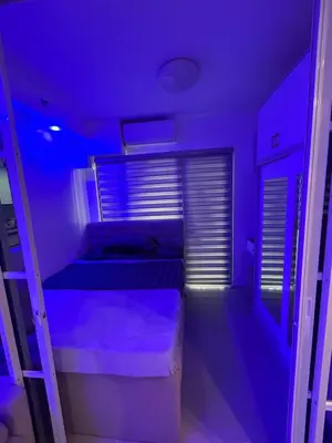 a purple room with two beds and a window at E&T staycation in Manila