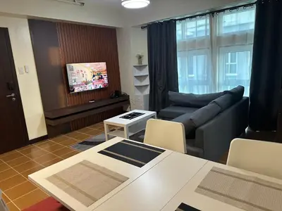 a living room with a couch and a table at 2BR Condo in Makati- Good for 6! in Manila