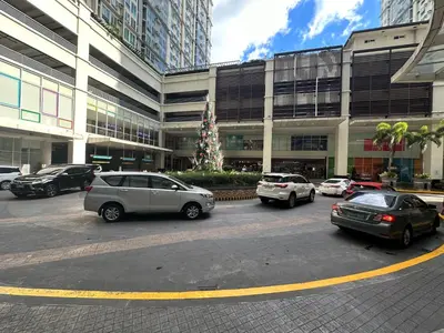 a parking lot with cars parked in front of a building at 2BR Condo in Makati- Good for 6! in Manila
