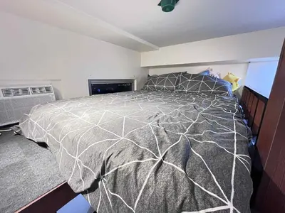 a bedroom with a bed with a gray and white comforter at Loft life Staycation in Manila