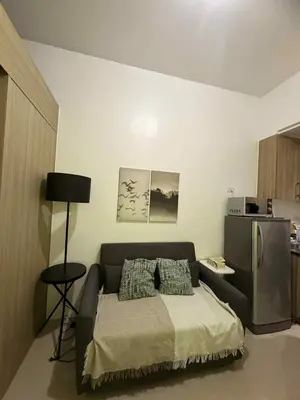 a bedroom with a bed and a refrigerator at Shore Residences 1BR Staycation in Manila