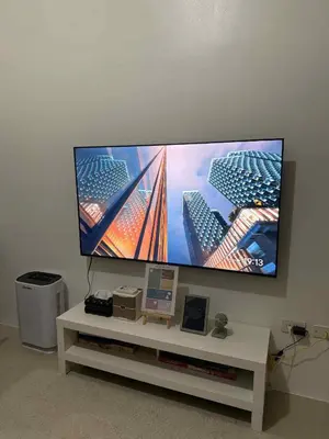 a flat screen tv sitting on a white tv stand at Shore Residences 1BR Staycation in Manila