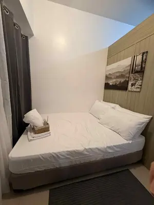a small bed with a box on it in a room at Shore Residences 1BR Staycation in Manila