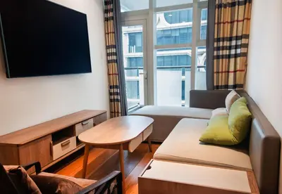 a living room with a couch and a flat screen tv at Grand Marina Residences in Manila