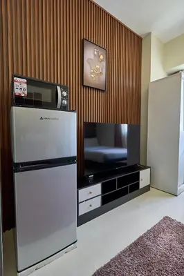 a kitchen with a refrigerator and a tv at Vista Blooms Stay at Vista Shaw with WiFi in Manila