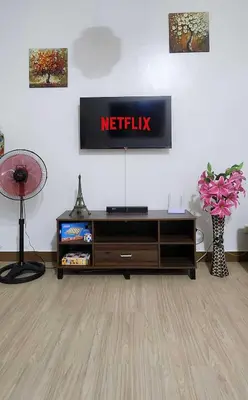 a living room with a television on a wall at Colin's Suite - Hope Residences, Trece Martires in Trece Martires