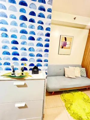 a living room with a blue and white wallpaper at Shore Residence hosted by Nara Homes in Manila