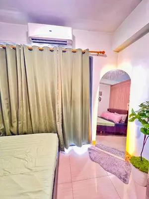 a living room with curtains and a bed at Shore Residence hosted by Nara Homes in Manila