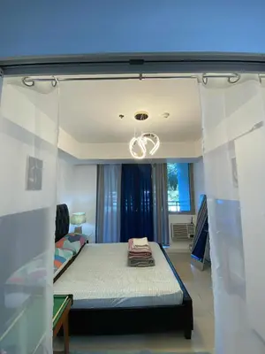 a room with a bed and a chandelier at Azure Daily by Trisha Sarmiento in Manila