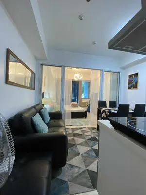 a living room with a leather couch and a table at Azure Daily by Trisha Sarmiento in Manila