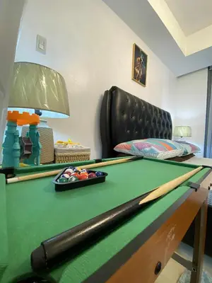 a room with a pool table and a chair at Azure Daily by Trisha Sarmiento in Manila