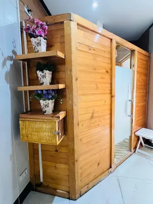 a wooden shower stall with flowers in a room at Alex Staycation Home in BGC in Manila