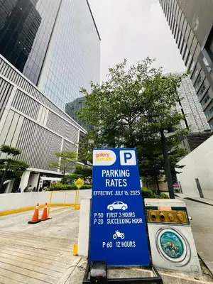 a parking rates sign in front of a parking lot at Alex Staycation Home in BGC in Manila