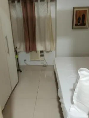 a white room with a bed and a window at Sea Residences By Queen in Manila